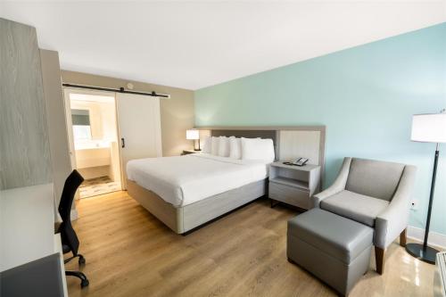 a hotel room with a bed and a chair at Best Western Seaside Inn in Saint Augustine Beach