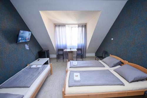 a room with three beds and a table and a window at Moderne Appartement in Nürnberg