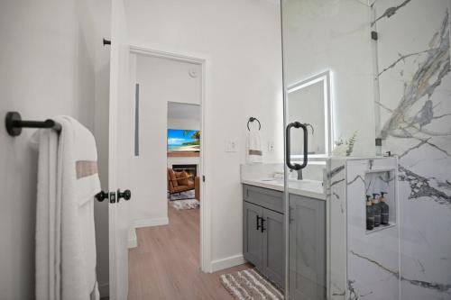a white bathroom with a sink and a shower at Stylish Cozy getaway in West Valley Area Heliport