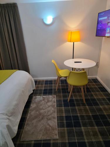 a hotel room with a bed and a table and a chair at MetroStay Manchester in Manchester