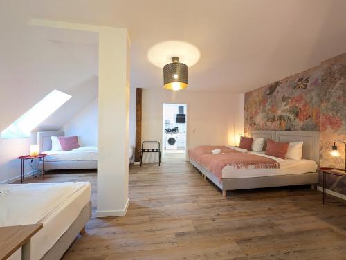 een slaapkamer met 2 bedden en een muur bij BohnApartments Schiller 7- Penthouse- WLAN- Parking- citynah in Erfurt