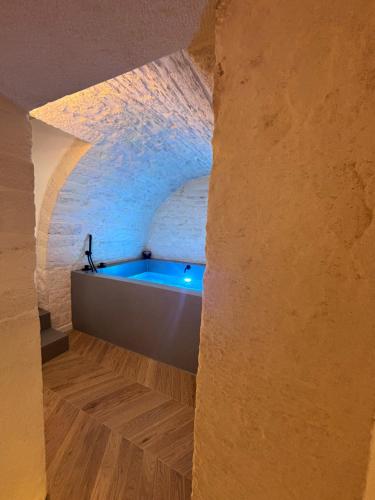 a bathroom with a tub in a stone wall at DORO' suite & luxury rooms in Noci