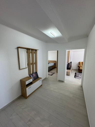 a living room with white walls and a mirror at Alkeo's Apartments in Shkodër