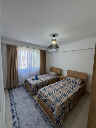 a hotel room with two beds and a window at Alkeo's Apartments in Shkodër