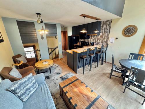 a living room and kitchen with a couch and a table at Ski-in Ski-out Townhome at Lutsen Mountain, Pool, Hot Tub, Fitness, Sauna and more! in Lutsen
