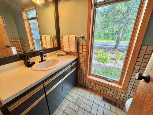 a bathroom with a sink and a window at Ski-in Ski-out Townhome at Lutsen Mountain, Pool, Hot Tub, Fitness, Sauna and more! in Lutsen