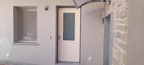 a white door in a building with a window at La Casetta in San Salvatore Monferrato