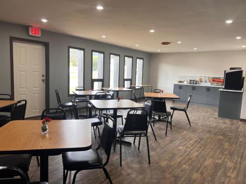 a cafeteria with tables and chairs and a kitchen at Capri Motor Inn in Smithers