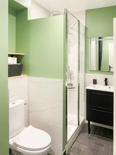 a bathroom with a toilet and a glass shower at Cocon design centre ville proche gare in Mâcon