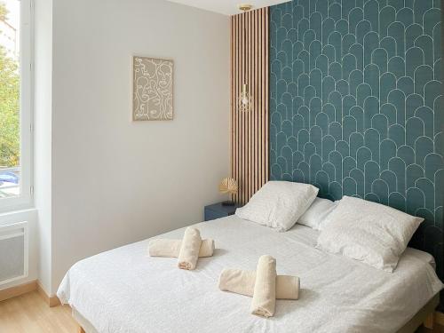 a bedroom with a bed with two towels on it at Cocon design centre ville proche gare in Mâcon
