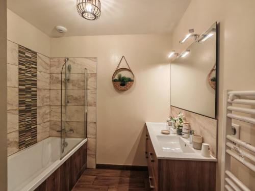 a bathroom with a tub and a sink and a shower at Le balcon des cimes in Adast