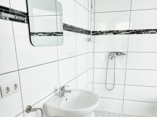 a white bathroom with a sink and a mirror at Deluxe Penthouse Suite zentral mit Goldstadtblick in Pforzheim