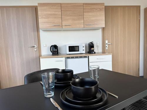a kitchen with a table with two bowls and glasses at Deluxe Penthouse Suite zentral mit Goldstadtblick in Pforzheim