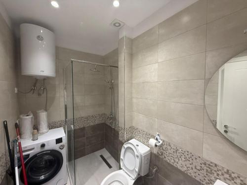 a bathroom with a toilet and a washing machine at Amaji Apartament Korcë in Korçë