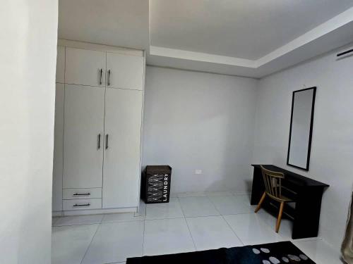 a white room with a desk and a chair at Zachi Zebra Apartment in Kitwe