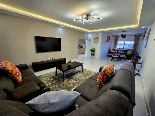 a living room with a couch and a flat screen tv at Zachi Zebra Apartment in Kitwe