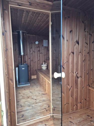 a room with a wood paneled room with a stove at Trzy Sówki in Ryki