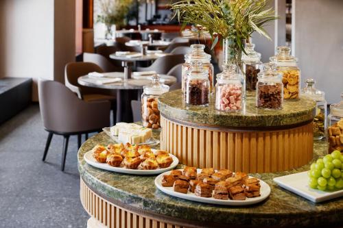 a buffet with plates of food on a table at RIHGA Royal Hotel Osaka, Vignette Collection by IHG in Osaka