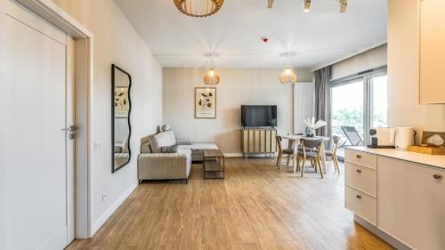 a living room with a kitchen and a dining room at MazuryHoliday Apartamenty Stranda nad jeziorem Kisajno in Giżycko