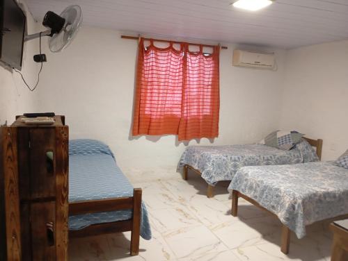a room with two beds and a window at La Baquiana 3 in Mercedes