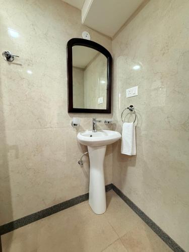 a bathroom with a sink and a mirror at Palm Residences and Suites in Jaipur