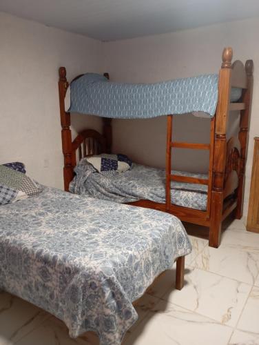 a bedroom with two bunk beds and a chair at La Baquiana 3 in Mercedes