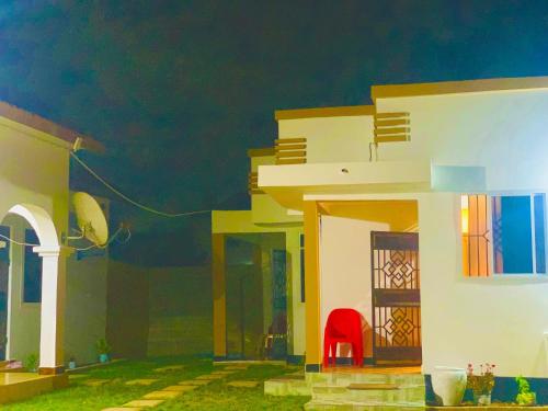 a house with a red chair in front of it at Freetime zone in Dar es Salaam