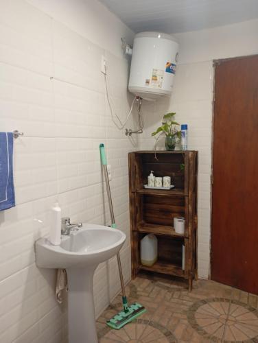 a bathroom with a white sink and a shelf at La Baquiana 3 in Mercedes