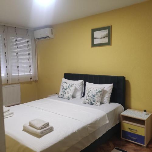 a bedroom with a bed with white sheets and pillows at DMB Apartments in Kragujevac