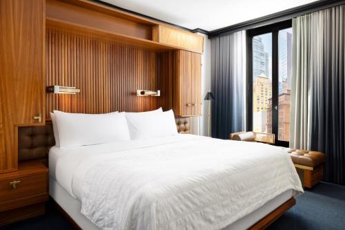a bedroom with a large white bed and a window at Le Meridien New York, Central Park in New York