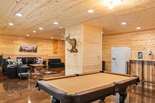 a pool table in a living room with a deer head on the wall at Mountain Views - Firepit - Gas Fireplace - Sleeps 15 in Grassy Creek