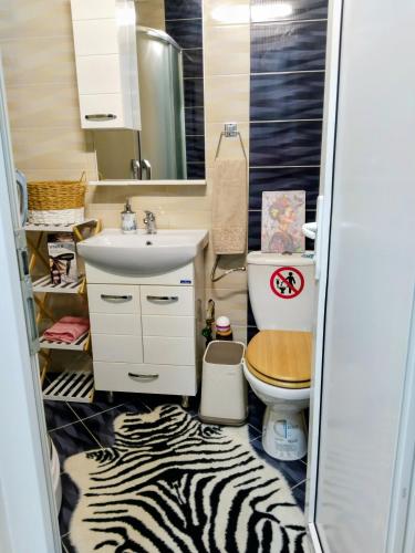 un bagno con stampa zebrata, lavandino e WC di Frida Apartment a Ohrid