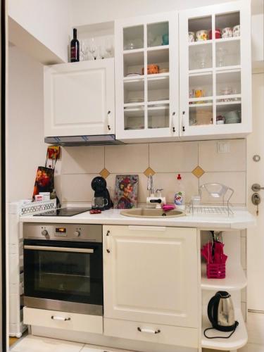 una cucina con mobili bianchi e un lavandino di Frida Apartment a Ohrid