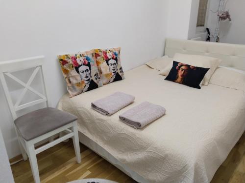 un letto con due cuscini e una sedia in una stanza di Frida Apartment a Ohrid