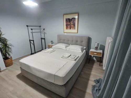 a bedroom with a large bed with white sheets at Chrysalis Apartment in Nea Potidaea