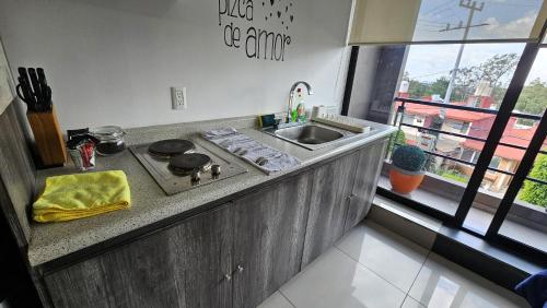 a kitchen with a stove and a sink and a window at S05 SUITE DOBLE CAMA MATRIMONIAL Premium Frente al TEC CEM con Cocineta WiFi Balcón Parking Terraza in Mexico City
