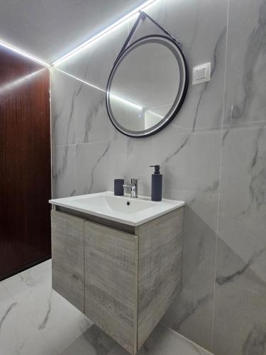 a bathroom with a sink and a mirror at Chrysalis Apartment in Nea Potidaea