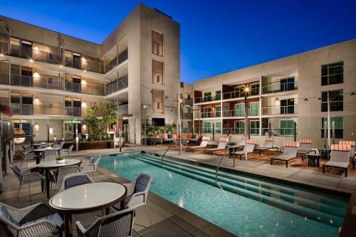 a swimming pool with tables and chairs next to a building at Luxury by the Beach with Pool, Gym, Game Room in Los Angeles