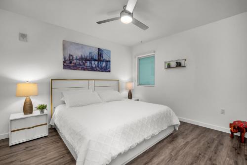 a white bedroom with a bed and a ceiling fan at Luxury by the Beach with Pool, Gym, Game Room in Los Angeles