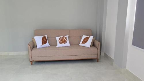 a couch with three pillows on it in a room at Suite Harmonia in Alto Paraíso de Goiás