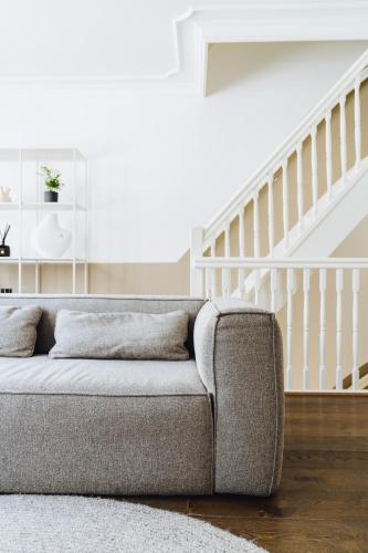 a couch in a living room with a staircase at Staal House in Amsterdam