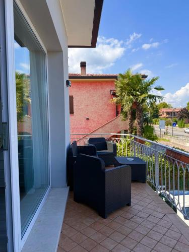 a balcony with two chairs and a couch at Cecilia Sirmione Appartamento in Sirmione