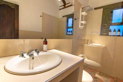 a bathroom with a sink and a toilet and a tub at Casa familiar con jacuzzi y vista increíble in Villa de Leyva