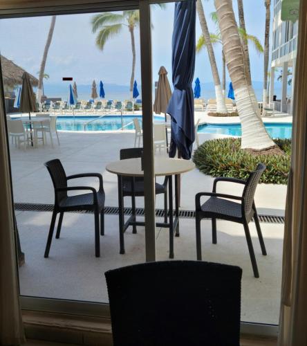 a table and chairs in front of a pool at Suites Atlas - Ocean Front in Bucerías