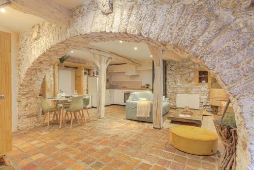 a kitchen and living room with a stone wall at L'Arche Dorée in Pouilly-le-Monial