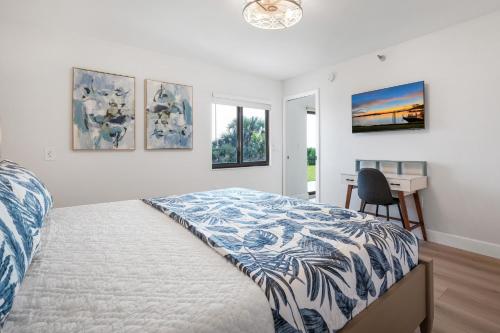 a bedroom with a bed and a desk in it at Updated direct oceanfront, ground floor condo with a heated pool and beach access in Bottle Island