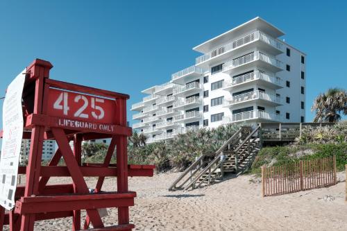 a sign on the beach in front of a building at Updated direct oceanfront, ground floor condo with a heated pool and beach access in Bottle Island