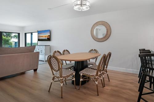 a dining room with a table and chairs and a couch at Updated direct oceanfront, ground floor condo with a heated pool and beach access in Bottle Island