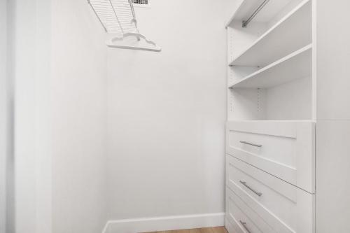 a white walk in closet with white cabinets at Updated direct oceanfront, ground floor condo with a heated pool and beach access in Bottle Island