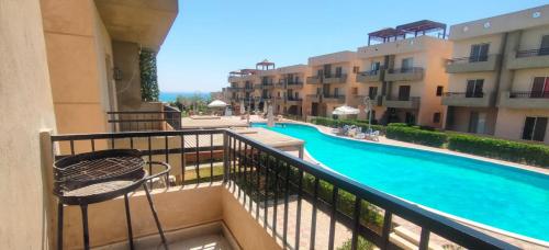 a view of a swimming pool from a balcony of a building at TAVIRA Rass Suder"For Family" in Raʼs Matarma